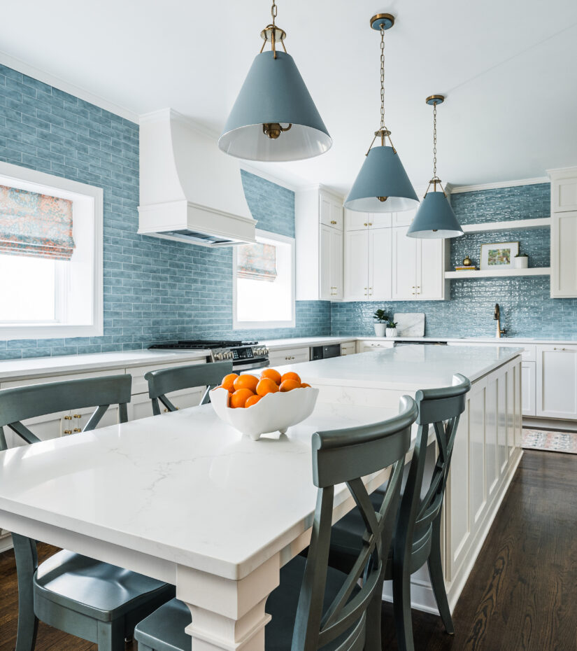 Charlotte kitchen design with a blue tile backsplash and warm finishes by Hayden Home Studio