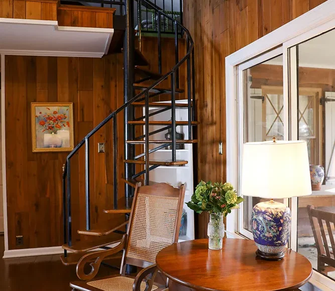 Black spiral metal staircase in a hardwood-floored room designed by Hayden Home Studio, Charlotte NC