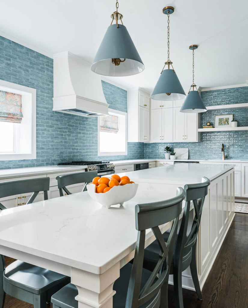 Charlotte kitchen design with a blue tile backsplash and warm finishes by Hayden Home Studio